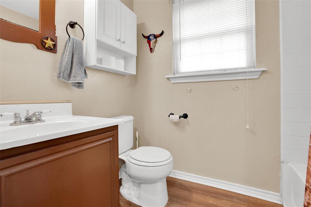 7634 Preston Road Denison, TX 75020 - Photo 18 of 34 a bathroom with a toilet a sink and a window