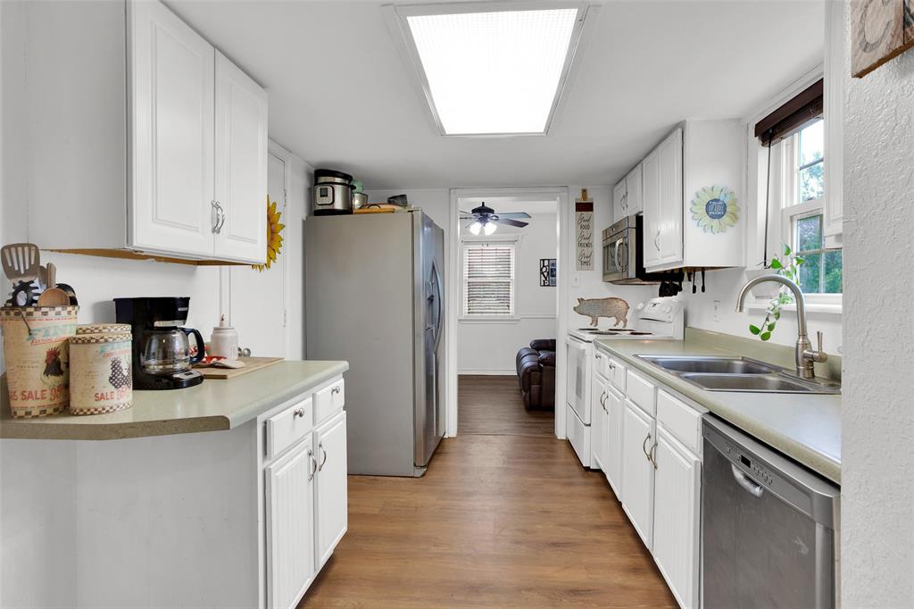 7634 Preston Road Denison, TX 75020 - Photo 6 of 34 a kitchen with stainless steel appliances granite countertop a sink stove refrigerator and cabinets
