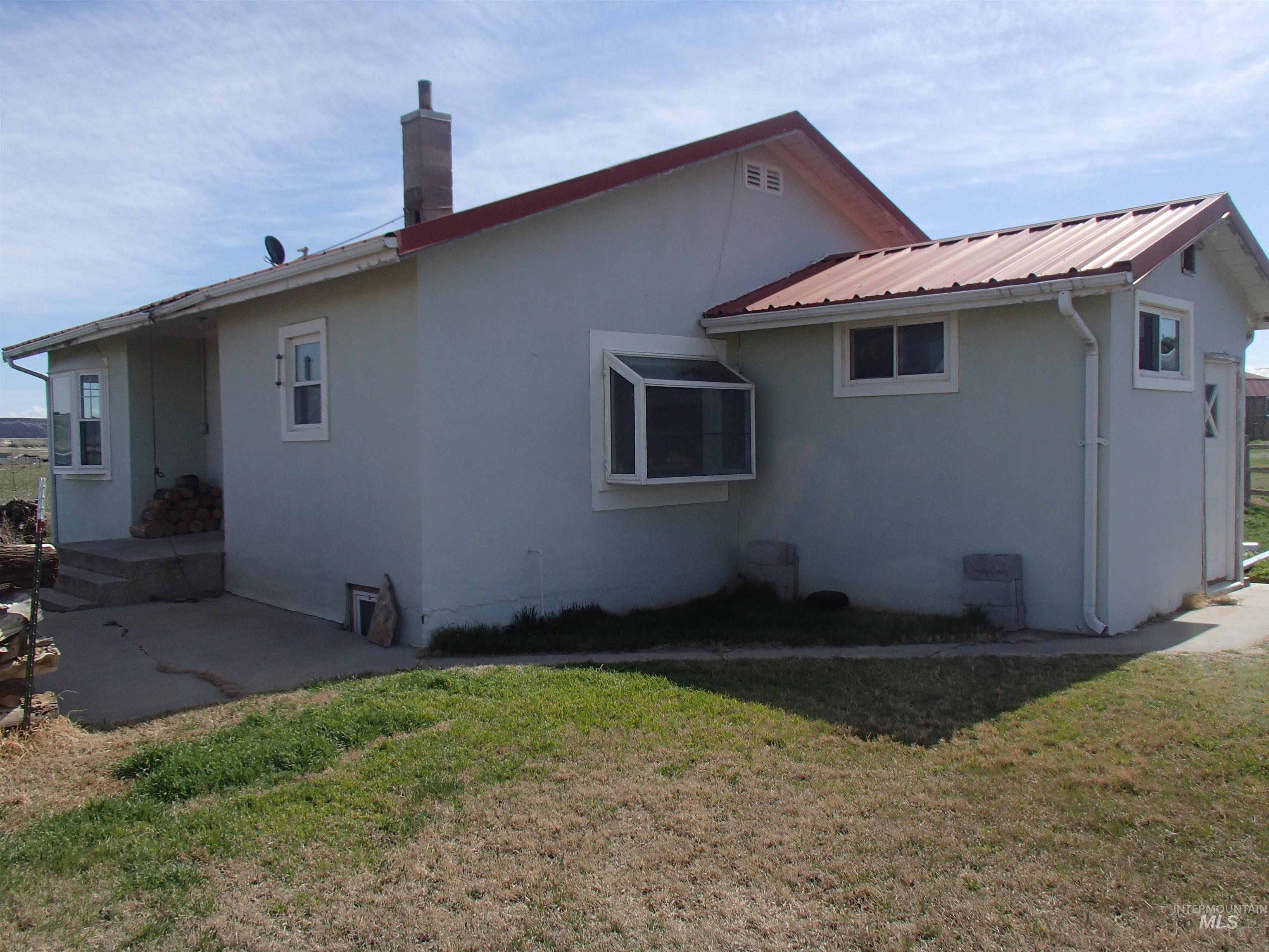 9506 Wright Road Melba, ID 83641 - Photo 16 of 37 view of property with a yard, a chimney, and stucco siding