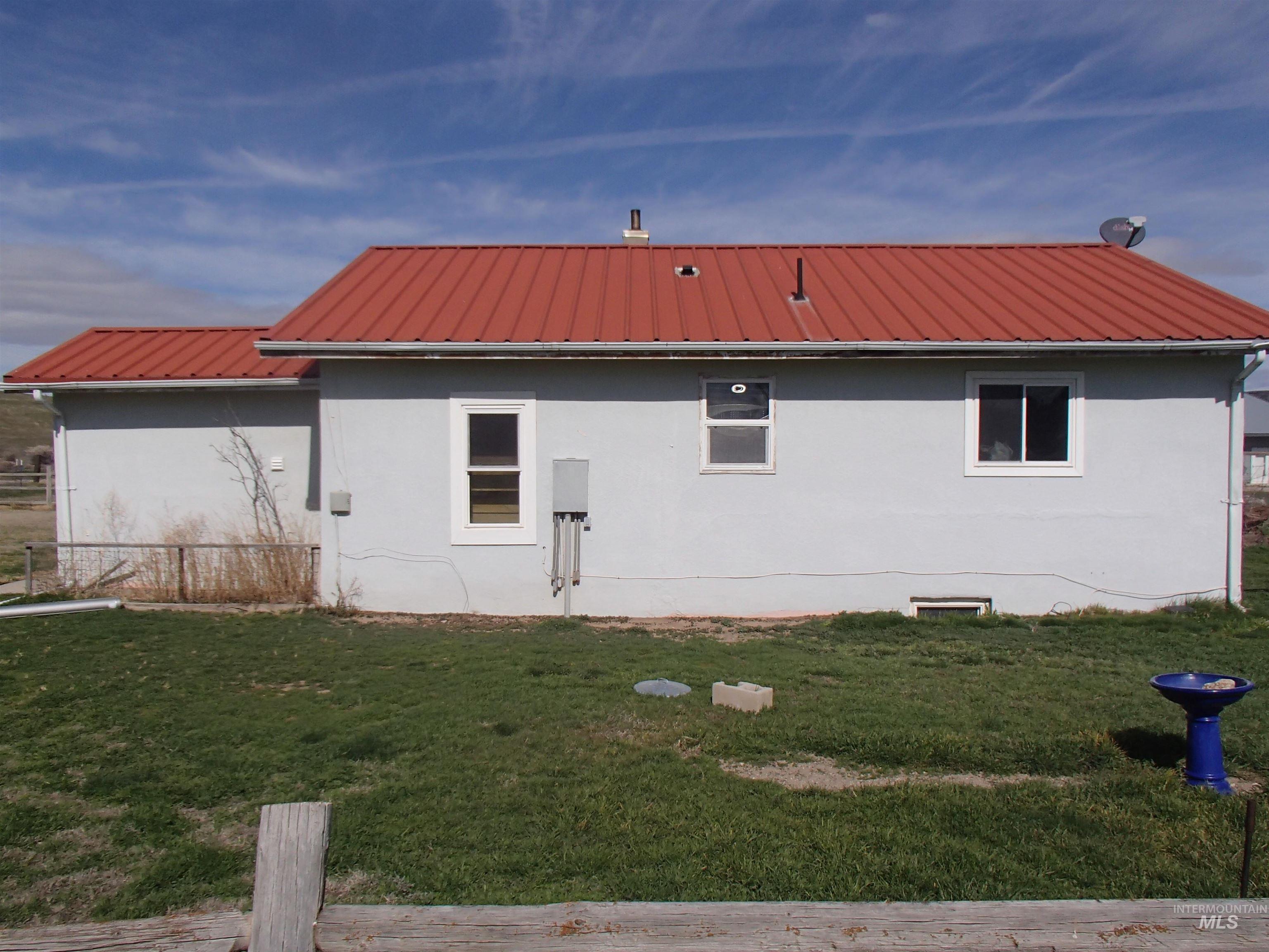 9506 Wright Road Melba, ID 83641 - Photo 17 of 37 Rear view of house featuring stucco siding and a metal roof