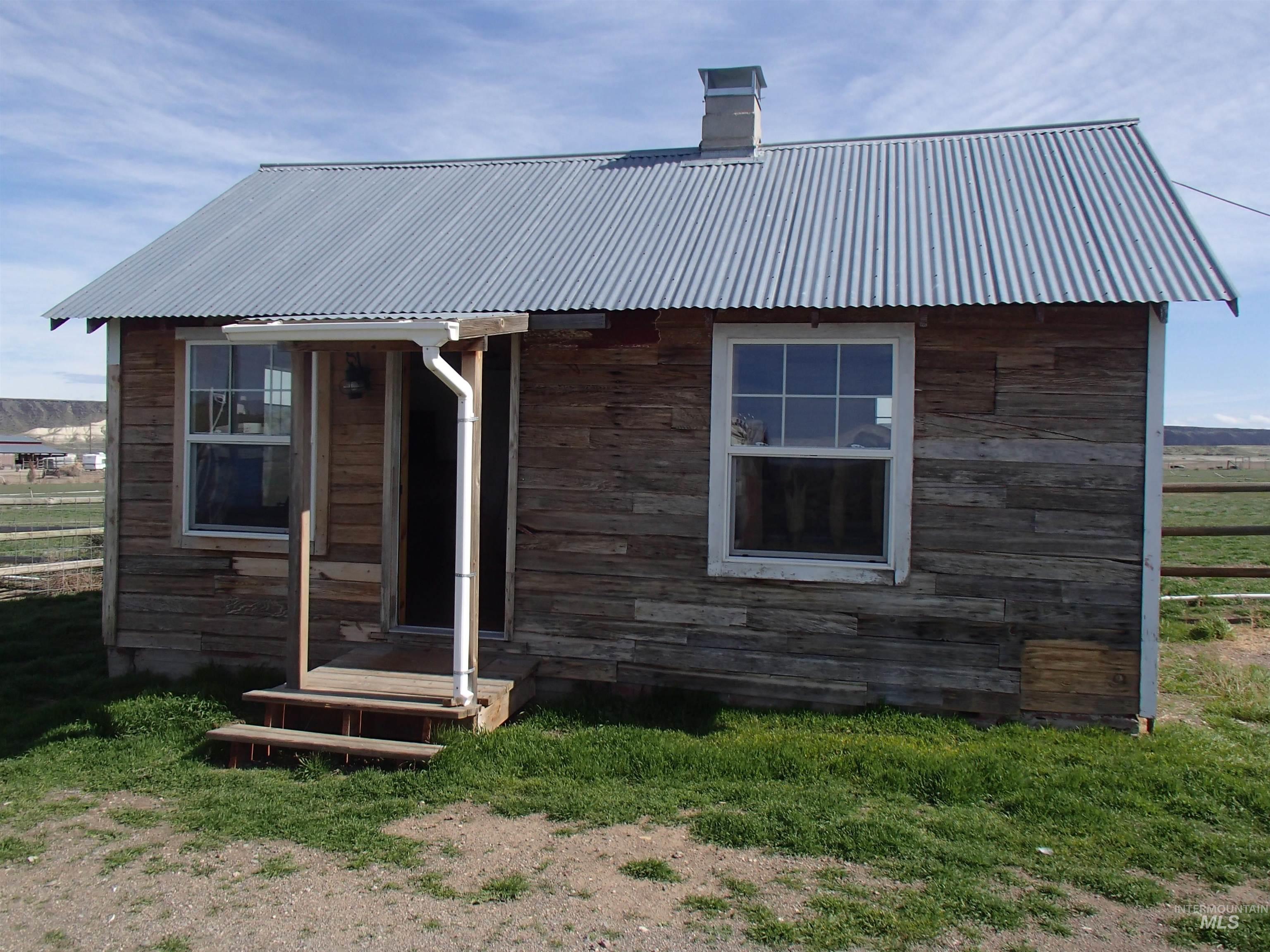 9506 Wright Road Melba, ID 83641 - Photo 18 of 37 View of front of studio featuring a metal roof, stone siding, and a chimney