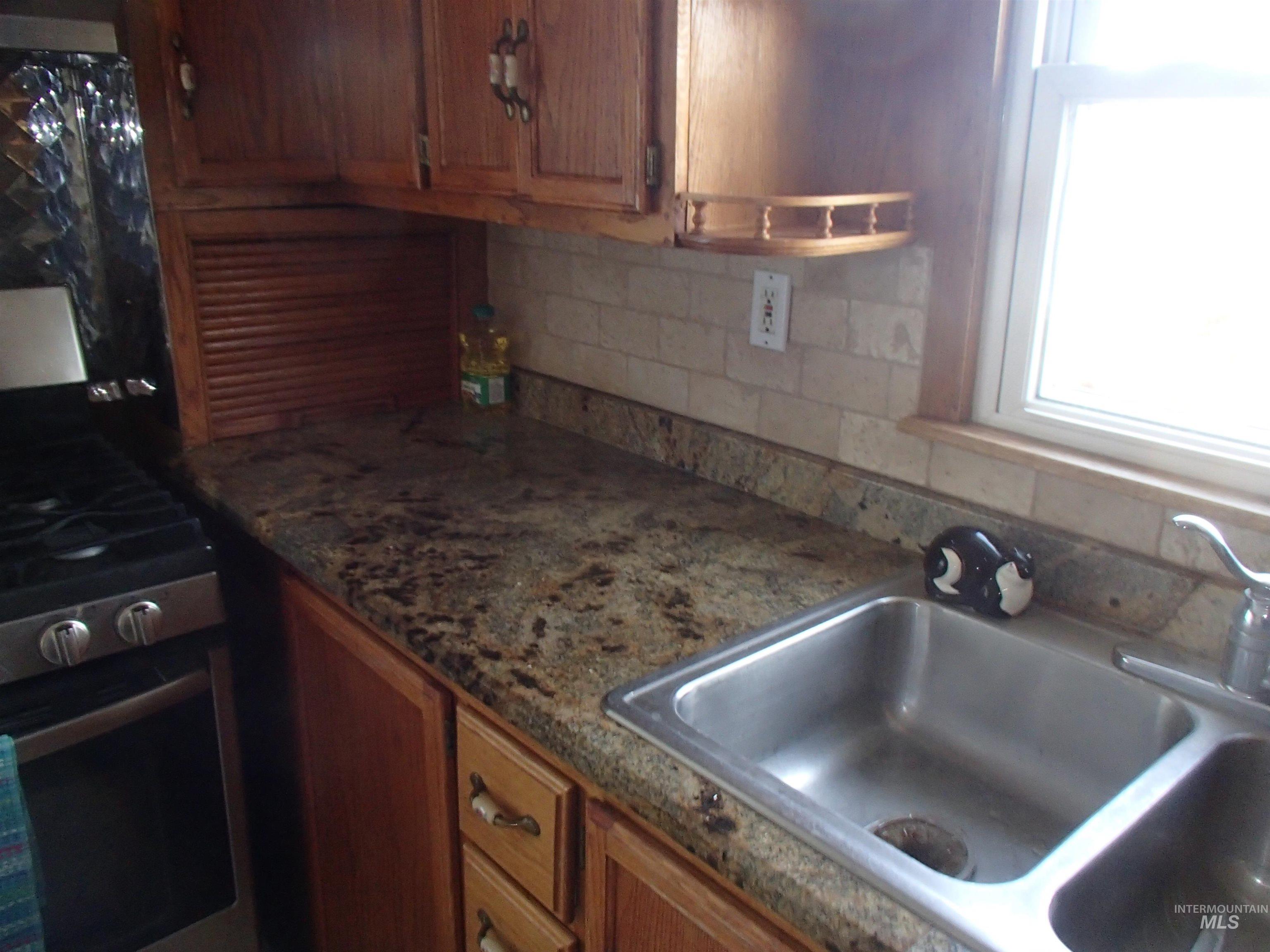 9506 Wright Road Melba, ID 83641 - Photo 7 of 37 Kitchen with decorative backsplash, wood finish cabinets, and stainless steel gas stove