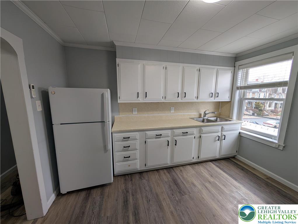 1111 Catasauqua Road, Unit 2 Whitehall, PA 18052 - Photo 6 of 9 a kitchen with granite countertop white refrigerator a sink dishwasher a stove and white countertops with wooden floor