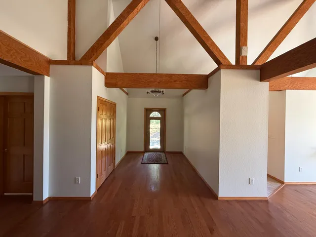 a view of a hallway with wooden floor and staircase