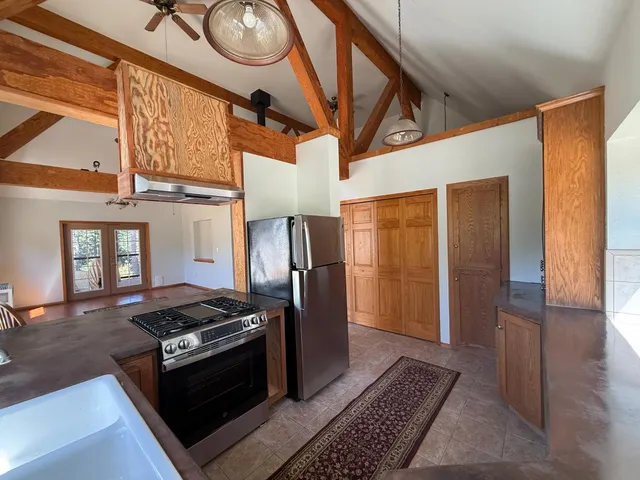 a kitchen with stainless steel appliances granite countertop a stove a refrigerator and a wooden cabinets