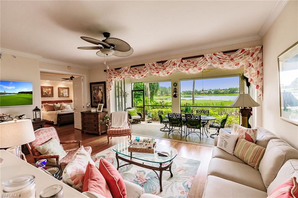 3910 Deer Crossing Court, Unit 1 Naples, FL 34114 - Photo 11 of 38 a living room with furniture ceiling fan and a large window
