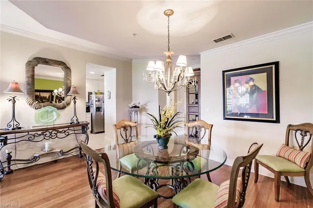 a view of a dining room with furniture a chandelier and wooden floor