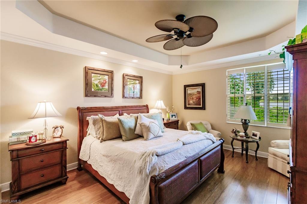 3910 Deer Crossing Court, Unit 1 Naples, FL 34114 - Photo 20 of 38 a bedroom with a bed and a chandelier