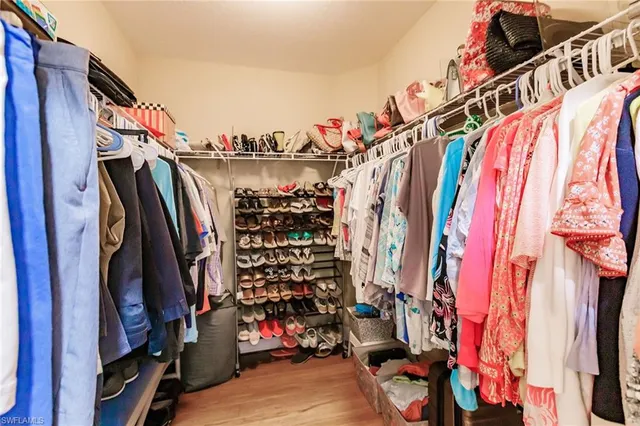 a view of walk in closet with clothes and shoes