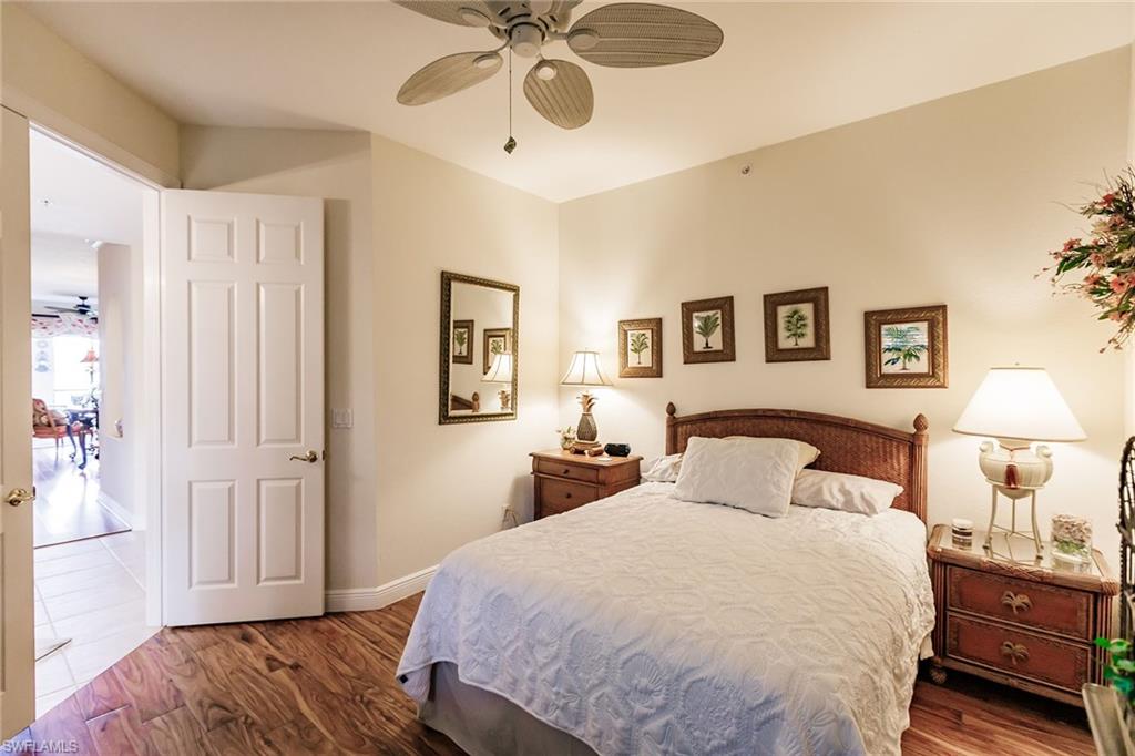 3910 Deer Crossing Court, Unit 1 Naples, FL 34114 - Photo 27 of 38 a bedroom with a large bed and a chandelier