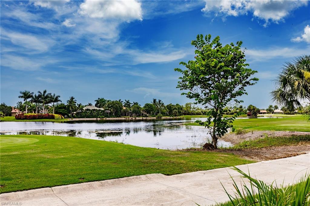 3910 Deer Crossing Court, Unit 1 Naples, FL 34114 - Photo 35 of 38 a view of a swimming pool with lawn chairs and a big yard