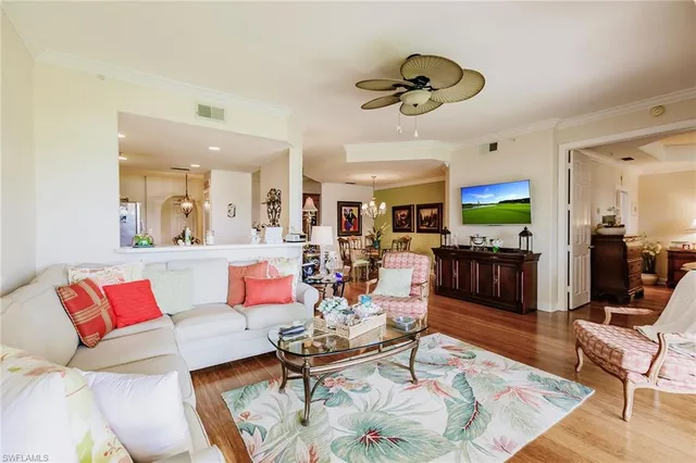 a living room with furniture kitchen view and a chandelier