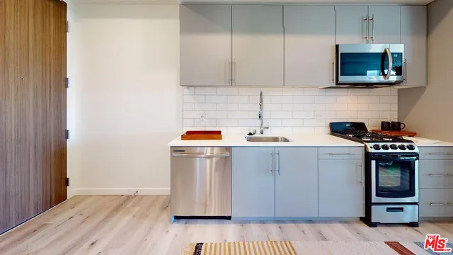 a kitchen with stainless steel appliances a stove microwave and cabinets