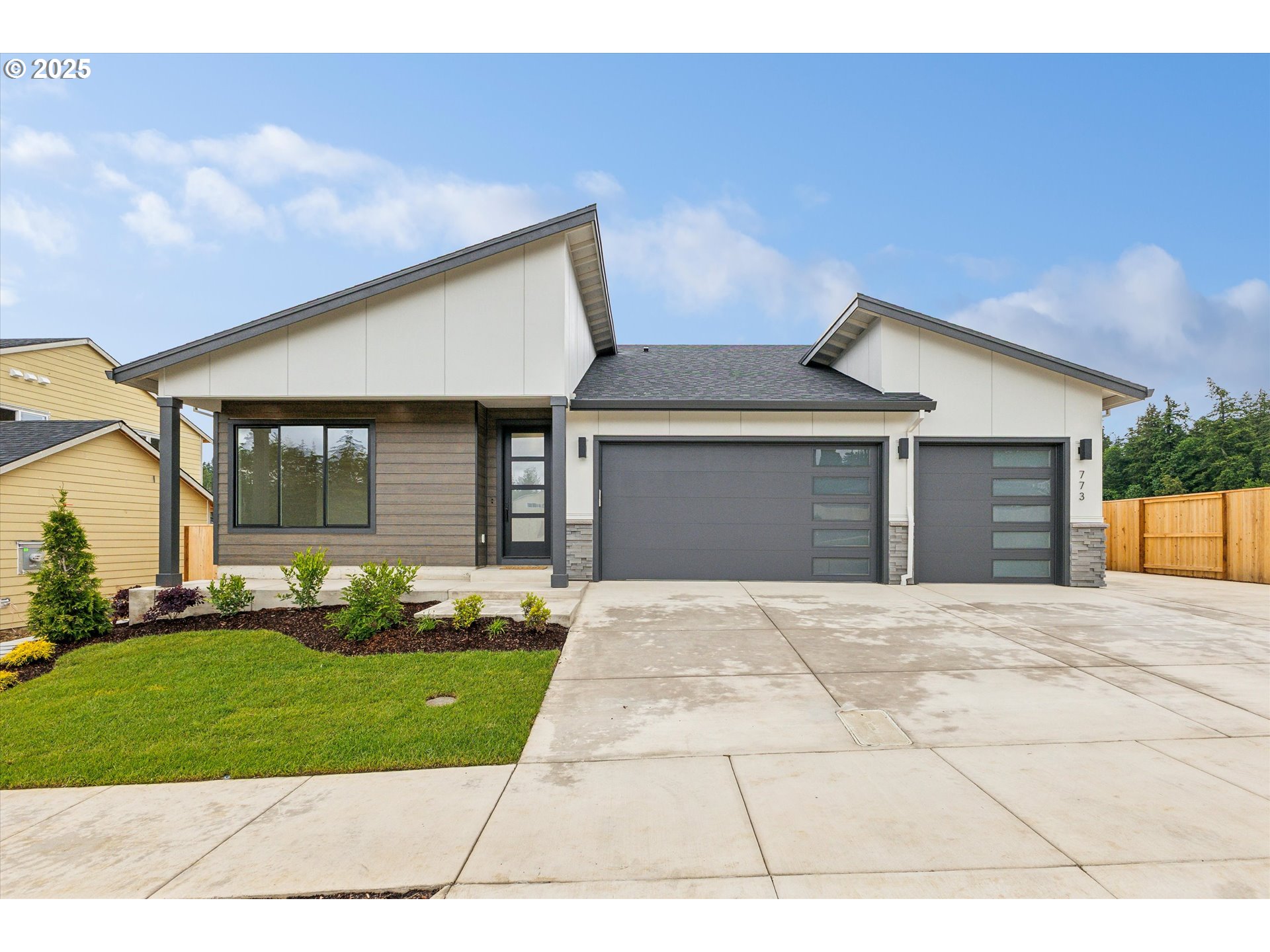 a front view of a house with a garden and plants