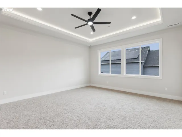 a view of an empty room with a ceiling fan