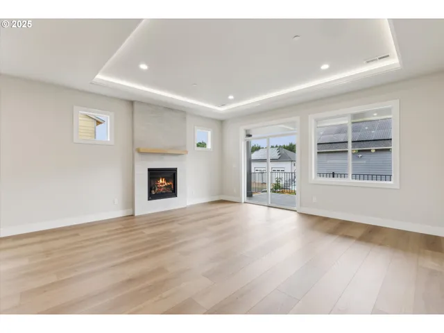 a view of an empty room with a window and fireplace