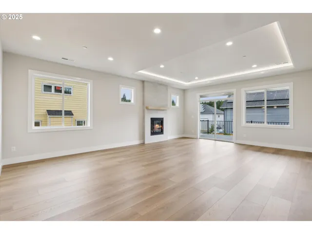 a view of an empty room with a window and fireplace