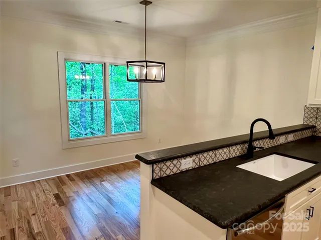 a kitchen with a table chairs and wooden floor