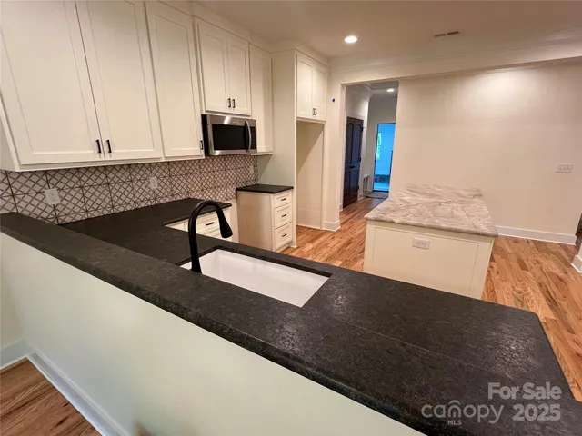 a kitchen with granite countertop sink and cabinets