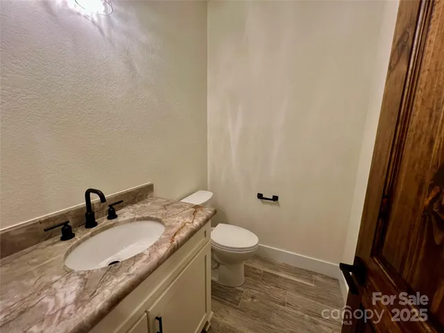 a bathroom with a granite countertop sink toilet and a mirror