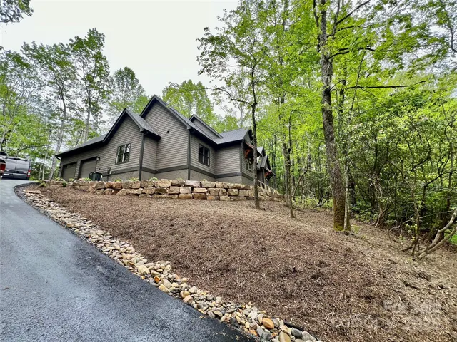 a view of a house with a yard and large trees