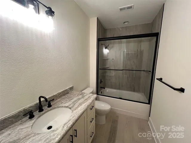 a bathroom with a sink mirror vanity and toilet
