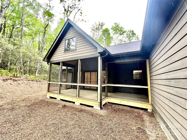 a view of backyard with a large window and wooden fence