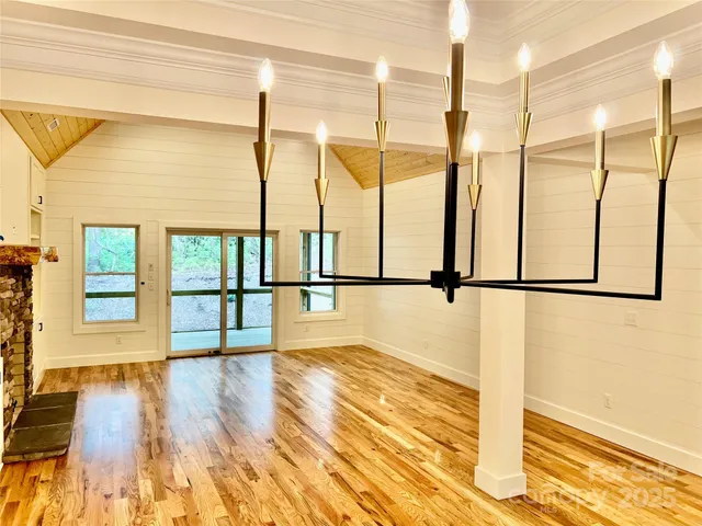 a view of empty room with wooden floor and windows