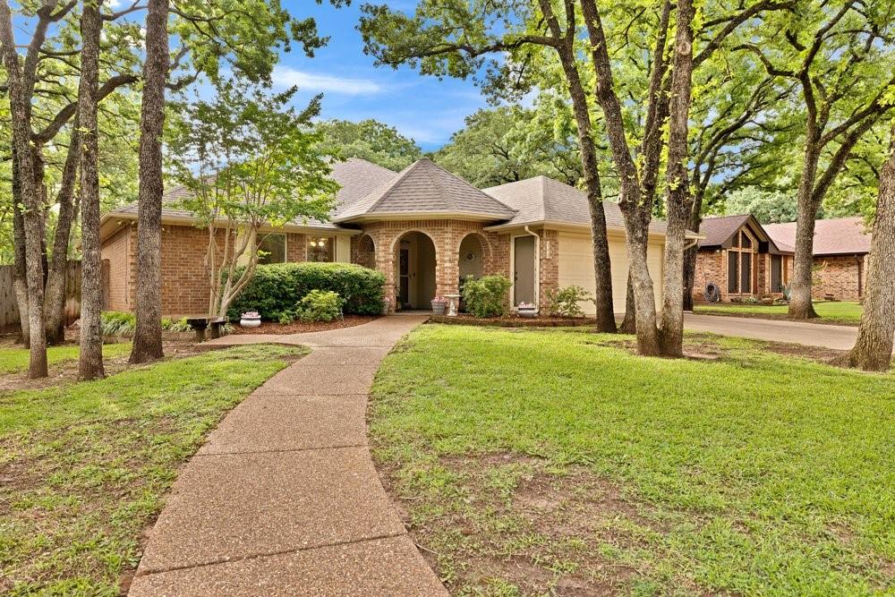 a front view of a house with a yard and trees