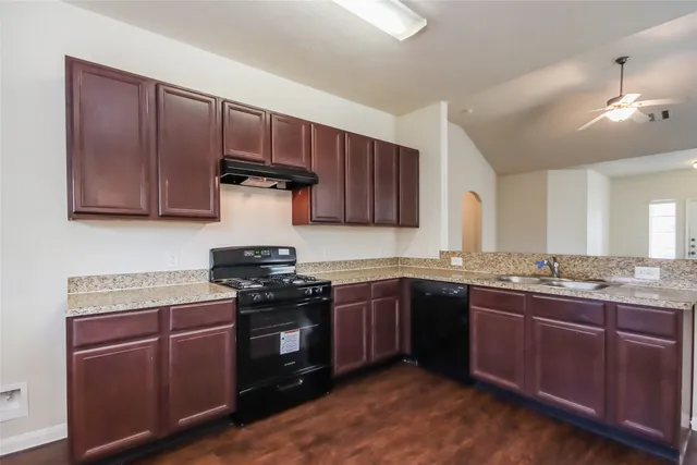 a kitchen with stainless steel appliances granite countertop wooden cabinets stove top oven and sink