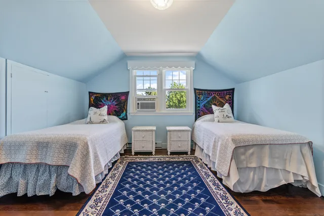 a bedroom with two beds and window