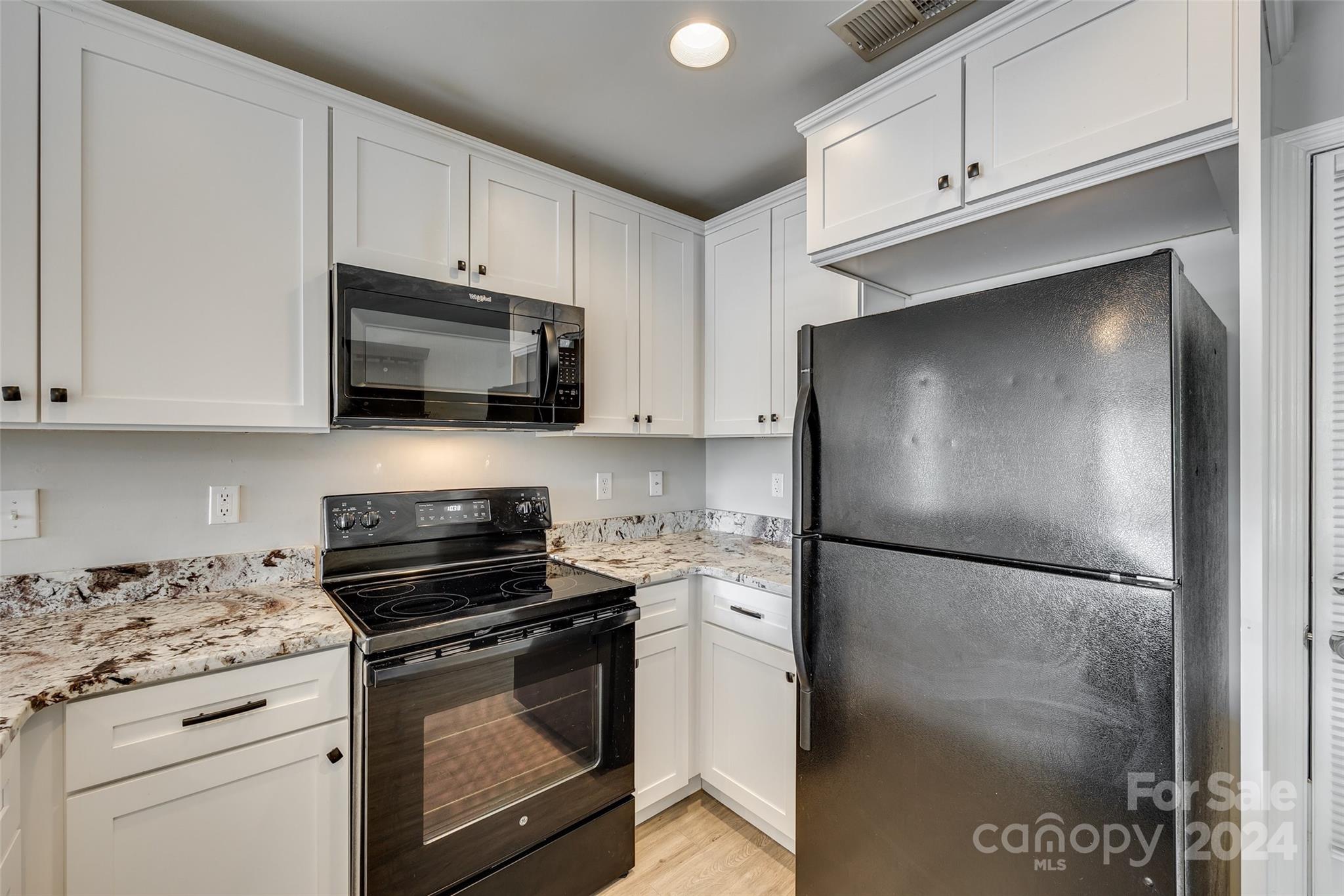 1446 Harpers Inlet Drive Clover, SC 29710 - Photo 11 of 28 a kitchen with a refrigerator stove and white cabinets