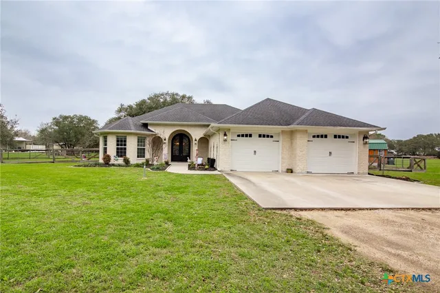 a front view of a house with a garden and yard