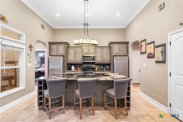 a kitchen with refrigerator and chairs