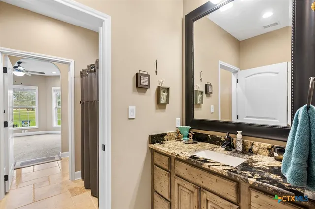 a bathroom with a granite countertop sink and a mirror