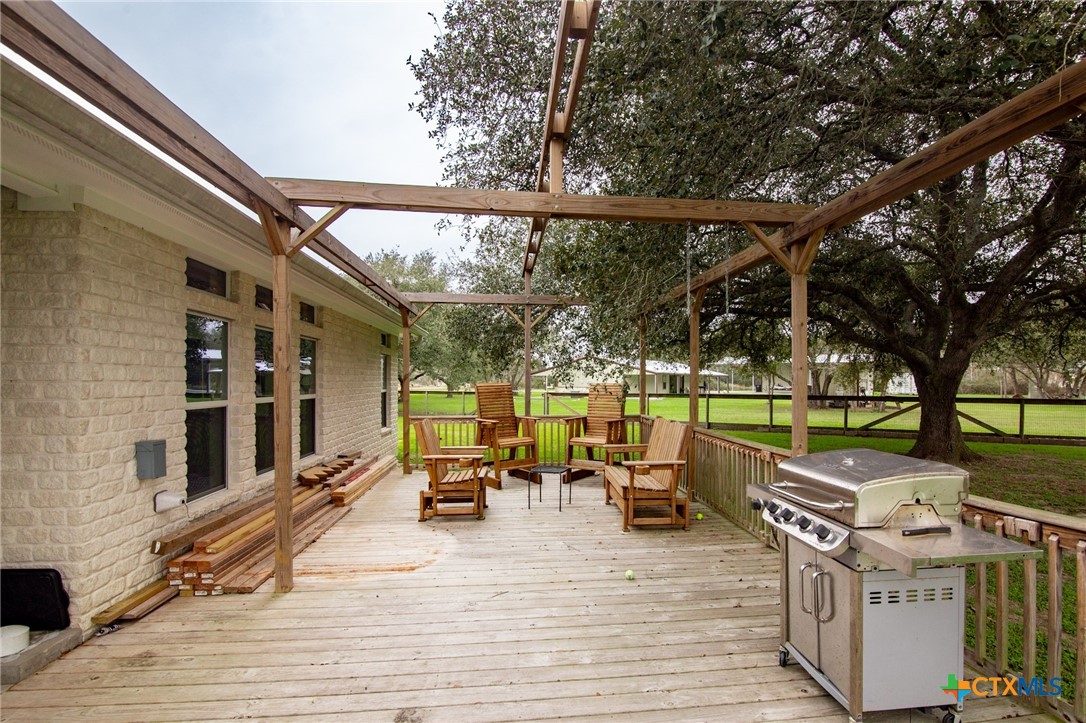 7134 Old Hwy Road Inez, TX 77968 - Photo 28 of 40 a view of a patio with table and chairs a barbeque with wooden floor and fence