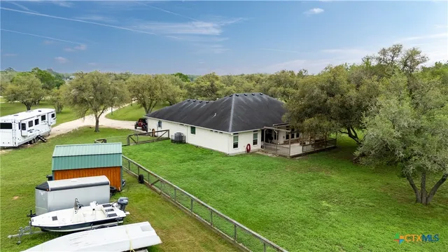 an aerial view of residential houses with outdoor space and trees