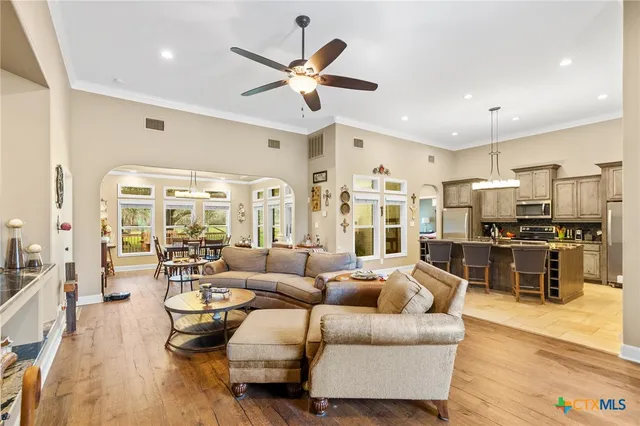 a living room with furniture kitchen view and a large window