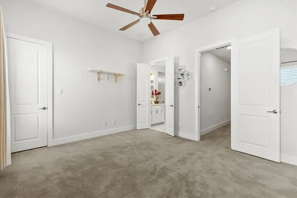 an empty room with closet and a ceiling fan