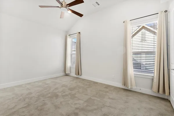 an empty room with a window and a fan