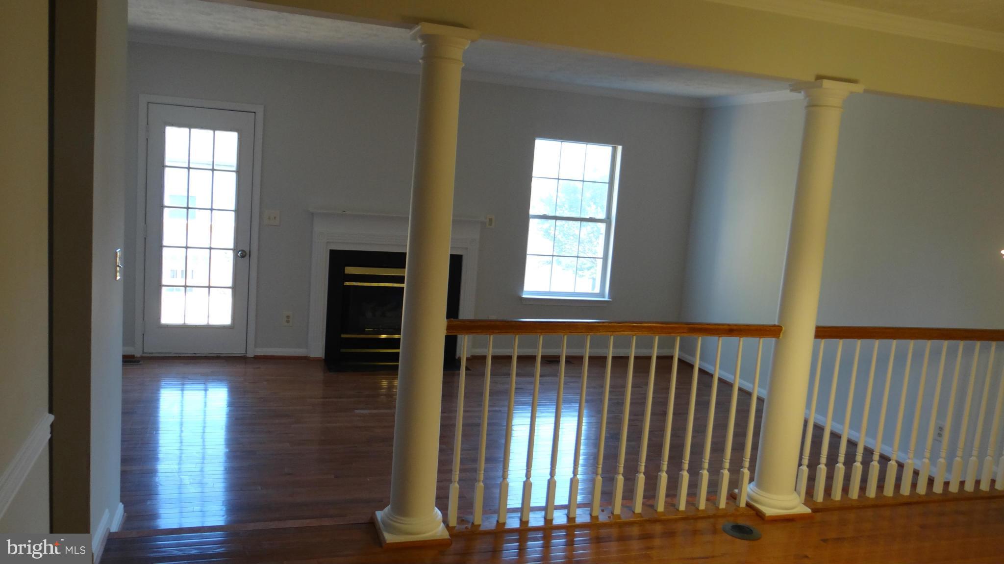 308 Rover Court Stafford, VA 22554 - Photo 6 of 14 an empty room with wooden floor windows and a fireplace