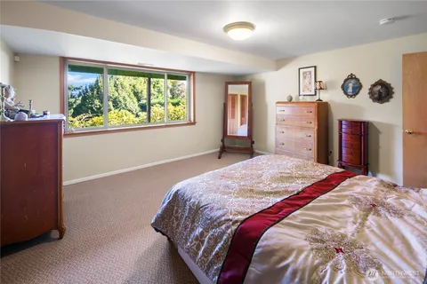 a bedroom with a bed and a large window