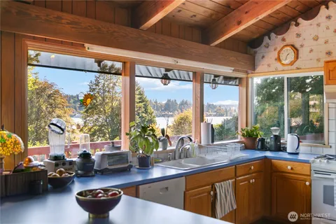 a kitchen with sink refrigerator and large window