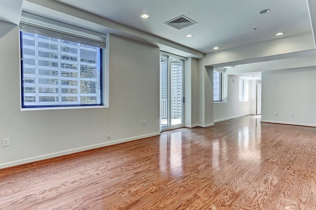 914 Main Street, Unit 1806 Houston, TX 77002 - Photo 1 of 21 an empty room with wooden floor and windows