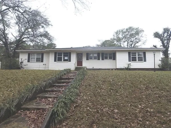 a front view of house with yard and trees around