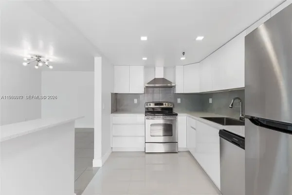a kitchen with a sink a refrigerator and cabinets