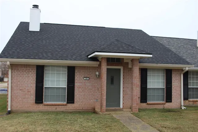 a front view of a house with a garden