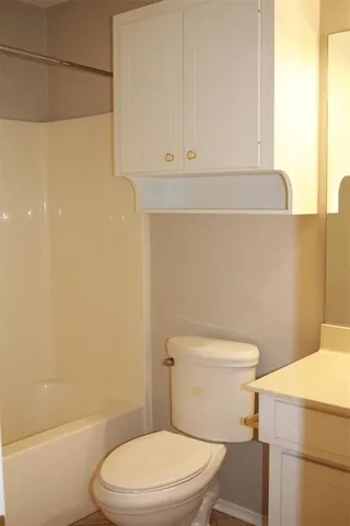 a white toilet sitting next to a bath tub