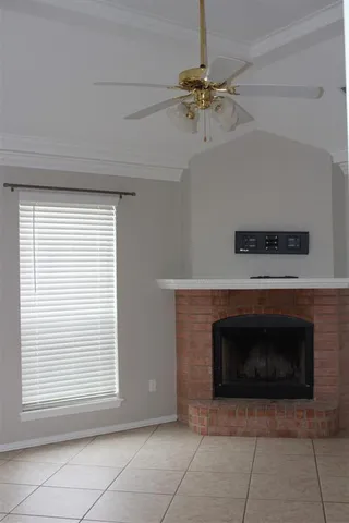 a view of an empty room with a fireplace and a window