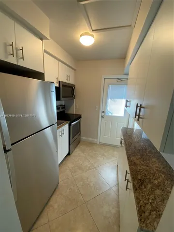 a kitchen with stainless steel appliances granite countertop a refrigerator and a stove